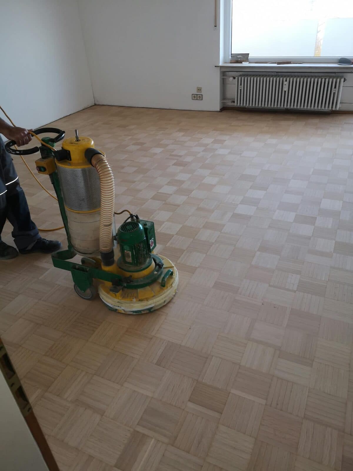 Bodenaufbereitung mit Schleifmaschine im leeren Raum